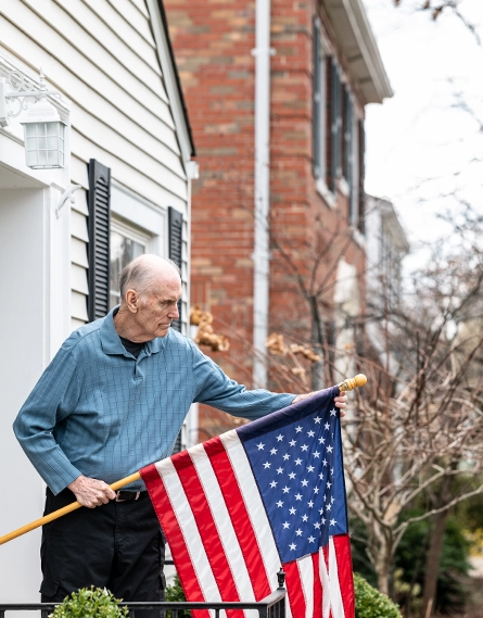 Photo of a patient, Tom holding a flag of the USA (photo)