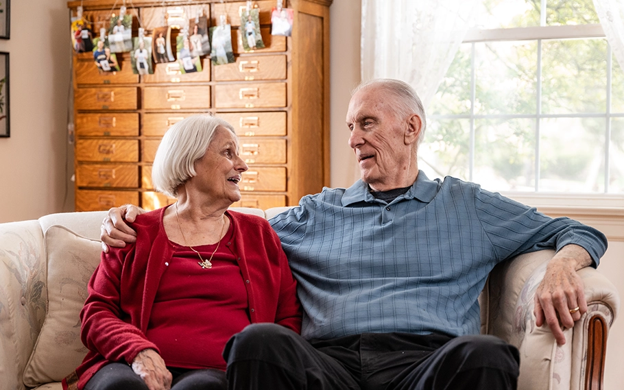 Photo of a patient, Tom and a woman (probably his wife) sitting on a sofa (photo)